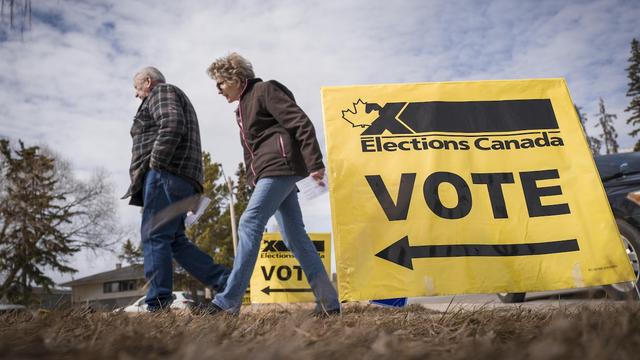 Des électeurs au moment d'arriver pour voter par anticipation aux élections fédérales de 2025 à Carstairs, en Alberta, le vendredi 18 avril 2025.