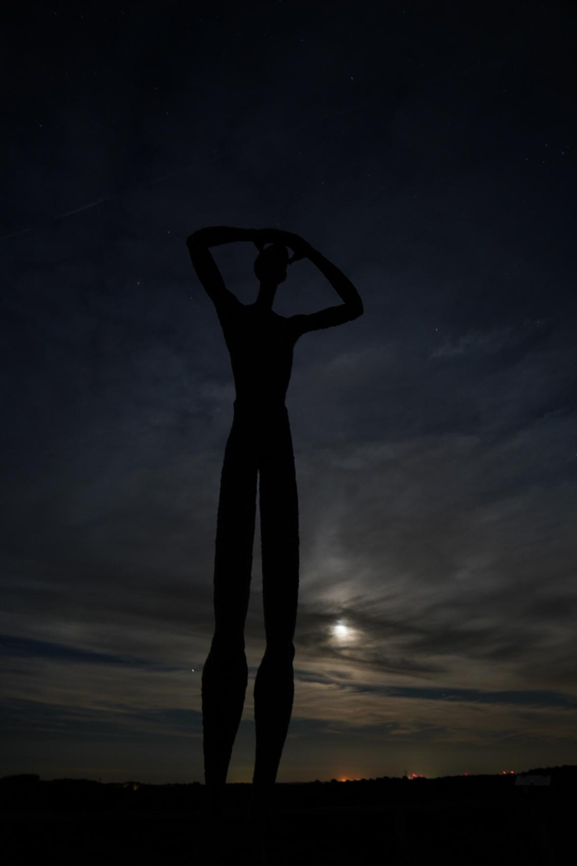 De Utkieker auf der deutschen Insel Spiekeroog bei Dunkelheit. Im Hintergrund ist der leuchtende Mond an einem wolkigen Himmel zu sehen. De Utkieker auf der deutschen Insel Spiekeroog bei Dunkelheit. Im Hintergrund ist der leuchtende Mond an einem wolkigen Himmel zu sehen.
