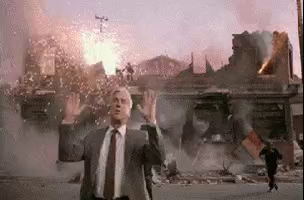 Filmszene
Im Hintergrund brennt ein Gebäude und es gibt Explosion. Menschen laufen davon. 
Eine ältere Person im Anzug sagt in aller Ruhe: Nothilfe to See here.