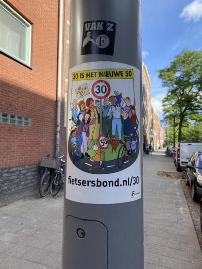 Ein bunter Aufkleber auf einem Laternenpfahl mit einer Cartoon-Illustration verschiedener Menschen, darunter Radfahrer und Fußgänger, wirbt für eine Kampagne mit dem Slogan „30 ist das neue 50“. Darauf ist ein Verkehrszeichen für eine Geschwindigkeitsbegrenzung abgebildet.