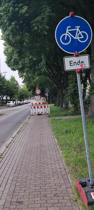 Foto eines Fahrradweges. 
Im Vordergrund ein Verkehrszeichen, das das Ende des Fahrradweges ankündigt. 20 Meter dahinter Verkehrszeichen, Durchfahrt verboten für Fahrräder. 5 Meter dahinter Verkehrszeichen, dass dort ein Radweg beginnt. 