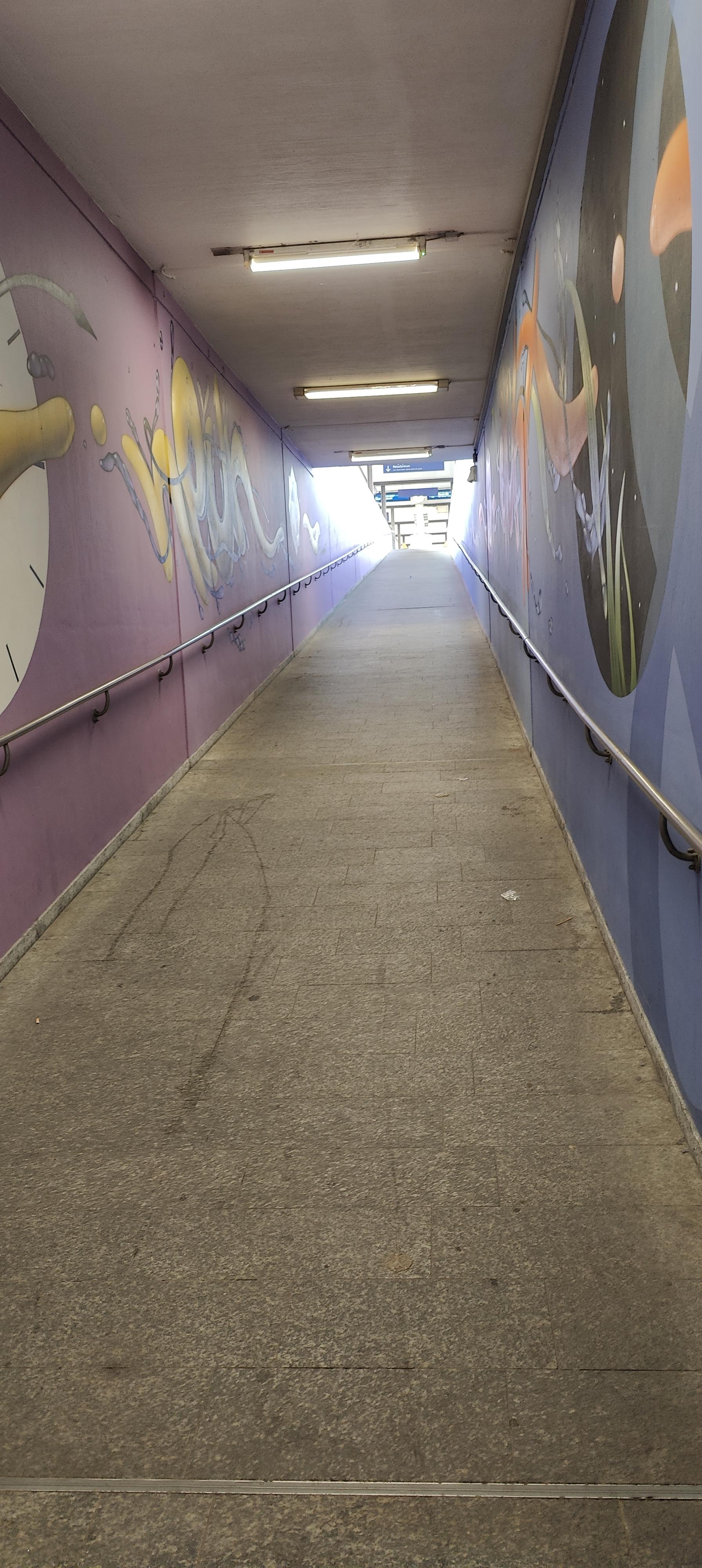 Rampe zum Bahnsteig, die Wände sind von Graffiti Künstler*innen professionell gestaltet