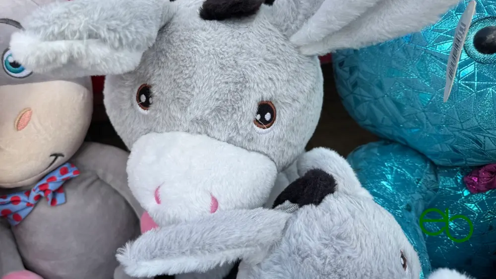 Mehrere Plüschtiere, vorne ein weiß-grauer Esel - Some plush toys, a white and gray donkey in the foreground