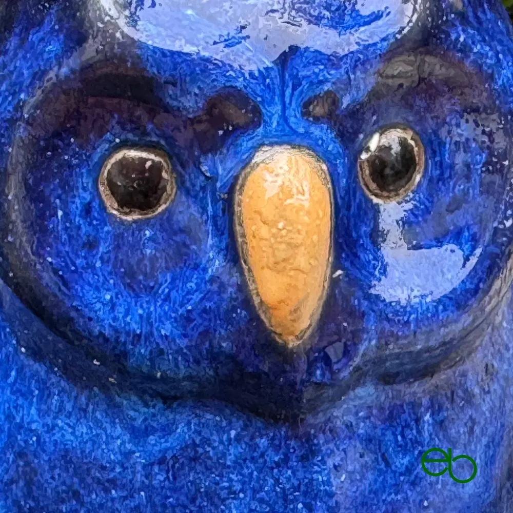 Head of a blue ceramic owl with a yellow beak