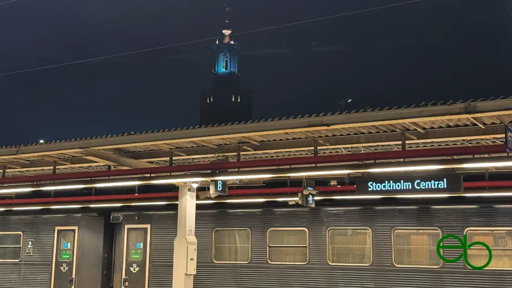 Night train in the central station of Stockholm, in the background the illuminated tower of a church